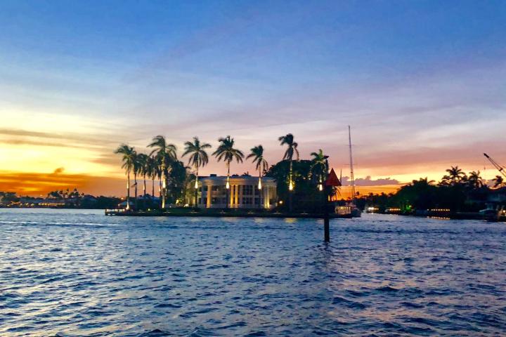 a sunset over a body of water with a city in the background